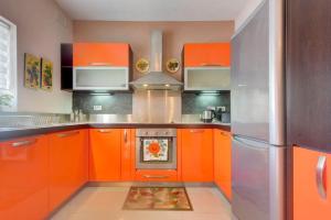 a kitchen with orange cabinets and an oven at Steps from the Sea, Side Sea-View, 3BR Sleep 6 in St. Paul's Bay