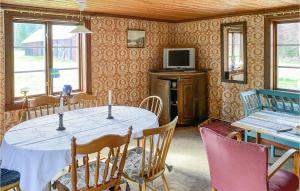 comedor con mesa y TV en Nice Home In Tjurstorp With Kitchen, 