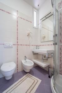 y baño con aseo, lavabo y espejo. en Residence Rizzante, en Caorle