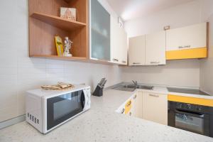 a kitchen with a microwave and a stove at Residence Rizzante in Caorle