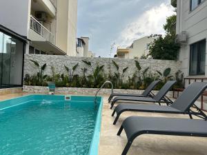 a swimming pool with lounge chairs next to a building at ECHINUS HOTELS in Lara