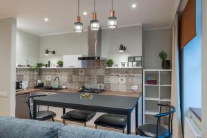 a kitchen and living room with a table and chairs at Friends and Family Vacation Apartments in Rīga