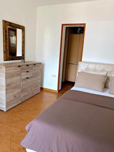 ein Schlafzimmer mit einem Bett und eine Kommode mit einem Spiegel in der Unterkunft Apartmani Stanojevic in Kotor