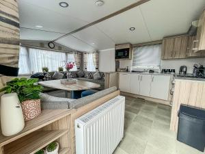 a kitchen and a living room with a table at Beautiful Caravan With Decking And Free Wifi At Highfield Grange Ref 26740wr in Clacton-on-Sea