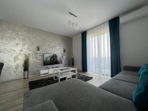 un salon avec un canapé et une télévision dans l'établissement Gala Residence Baile Felix, à Cordău