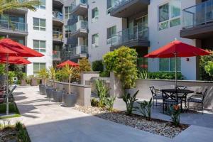 un patio con tavoli e ombrelloni rossi di fronte a un edificio di Mission Valley 1br w gym wd pool nr shops SAN-19 a San Diego