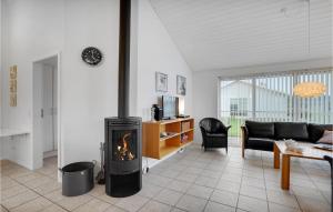 ein Wohnzimmer mit einem Kamin und einem Sofa in der Unterkunft Gorgeous Home In Nrre Nebel With Wifi in Lønne Hede