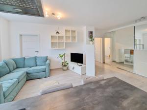 un soggiorno con un divano blu e una TV di Mirvana Apartments Azur Skyview a Timişoara