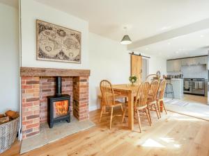 a living room with a brick fireplace and a table and chairs at Avondale in Woodgreen