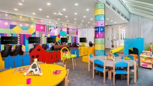 a childrens play room with tables and chairs at Amadria Park Beach Hotel Niko in Šibenik