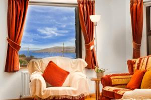 a living room with a chair and a large window at Cottage 118 - Cleggan in Cleggan