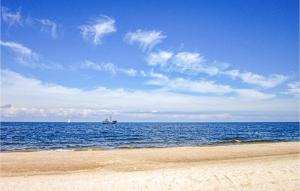 a boat in the water on the beach at 3 Bedroom Amazing Home In Grzybowo in Grzybowo