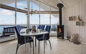 une salle à manger avec une table, des chaises et une cheminée dans l'établissement Stunning Home In Haderslev With 2 Bedrooms And Wifi, à Kelstrup Strand