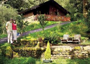 a man and a woman standing in front of a house at Springwood Lodges in Harrogate