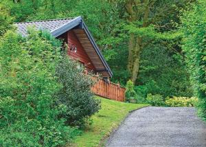 una casa con una valla al lado de un camino de grava en Springwood Lodges en Harrogate