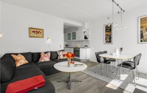 uma sala de estar com um sofá preto e duas mesas em Fan Bad, Lejl, 57 em Fanø