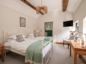 a bedroom with a bed and a desk and a tv at The Granary in Newport