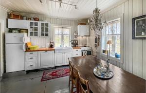 uma cozinha com armários brancos e uma mesa de madeira em Nice Home In yer With Kitchen em Øyer