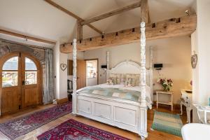 ein Schlafzimmer mit einem weißen Himmelbett und einem Schreibtisch in der Unterkunft The Hideaway - Luxury Cottages in York
