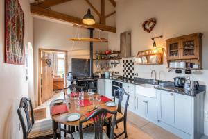 eine Küche mit einem Holztisch mit Stühlen und einem Tisch in der Unterkunft The Hideaway - Luxury Cottages in York