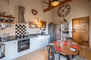 eine Küche mit einem Tisch und einer Uhr an der Wand in der Unterkunft The Hideaway - Luxury Cottages in York