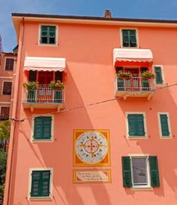 a orange building with a clock on the side of it at La Nuova Paranza - Le Grazie - Portovenere - Cinque Terre in Portovenere