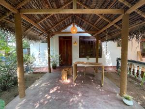 een patio met een houten tafel voor een huis bij Salty Garden Arugambay in Arugam Bay