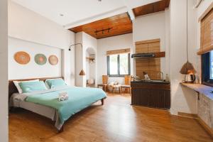 a bedroom with a bed and a kitchen and a sink at Chaca Beach House in Da Nang
