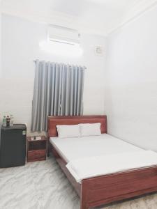 een slaapkamer met een groot bed en een raam bij KHÁCH SẠN VĂN KHANG in Bạc Liêu