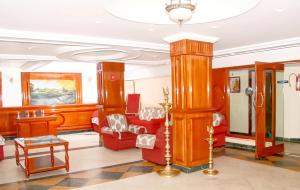 uma sala de estar com mobiliário vermelho e um lustre em Hotel SV International- Powered by Stayflexi em Kodaikanal