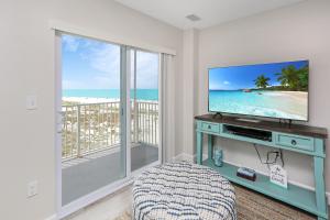 Una habitación con televisión y un balcón con vista al mar. en Surfside 17 by Pristine Properties Vacation Rentals, en Mexico Beach