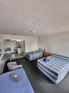 a hotel room with two beds and a desk at Kulgera Roadhouse in Kulgera