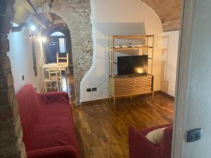 een woonkamer met een bank, een televisie en een boog bij Casa Centrale in Pisa