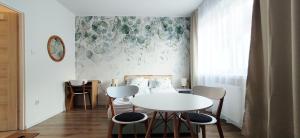 a dining room with a white table and chairs at Zielona Noc in Polanica-Zdrój