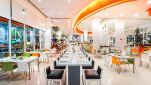 a dining room with tables and chairs in a restaurant at HARRIS Hotel Batam Center in Batam Center
