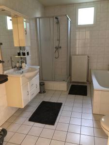 a bathroom with a shower and a sink and a tub at Luxe watervilla met eigen aanlegsteiger geschikt voor maximaal 6 personen in recreatiegebied de Gouden Ham in Maasbommel in Maasbommel