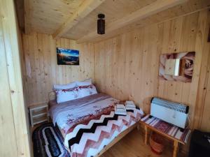 a small room with a bed in a cabin at Casa Poiana Teiului in Poiana Teiului