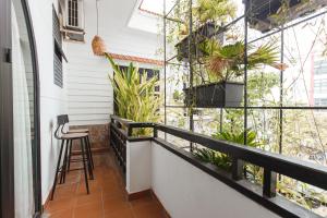 a balcony with a table and chairs and plants at Chaca Beach House in Da Nang