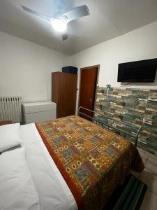 een slaapkamer met een bed met een deken erop bij la casina rossa B&B "Da capachiatta" in San Sebastiano al Vesuvio