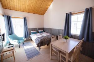 オウルにあるNallikari Holiday Village Cottagesのベッド、テーブル、椅子が備わる客室です。
