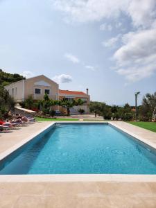 a swimming pool in front of a house at Luxe Villa Amfiario in Attica region, pool & breathtaking views! in Kalamos