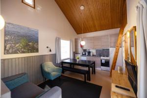 ein Wohnzimmer mit einem Esstisch und einer Küche in der Unterkunft Nallikari Holiday Village Cottages in Oulu