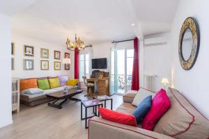 een woonkamer met een bank en een tafel bij Le Voeu - Appartement avec vue sur Nice in Nice
