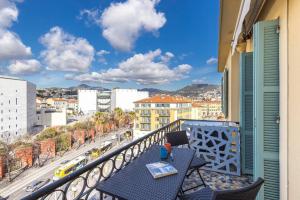 een balkon met een tafel en uitzicht op de stad bij Le Voeu - Appartement avec vue sur Nice in Nice