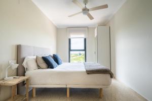 een slaapkamer met een bed en een plafondventilator bij Magnifico apartamento en Canet Playa by Hometels in Canet de Berenguer