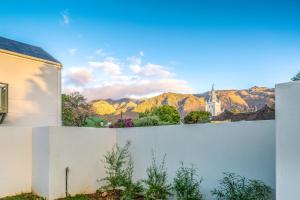 een wit hek met bergen op de achtergrond bij Monte Vista Boutique Hotel in Montagu