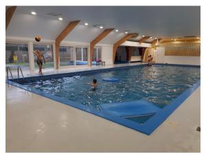 ein großes Schwimmbecken mit einem Jungen im Wasser in der Unterkunft Chalet Woods in Durbuy
