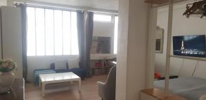 ein Wohnzimmer mit einem Sofa und einem TV in einem Zimmer in der Unterkunft Charming Loft - Tour Eiffel/ Rue Cler in Paris