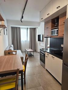 eine Küche und ein Esszimmer mit einem Tisch und einem Zimmer in der Unterkunft Andes Apartments in Ioannina