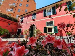 een roze gebouw met bloemen ervoor bij Boutique Hotel Novecento in La Spezia